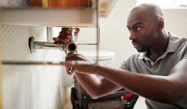 a male plumber fixing a bathroom faucet in Leander, TX - Leander, TX a male plumber fixing a bathroom faucet in Leander, TX - Leander, TX